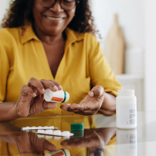Medication adherence: Mature woman taking tablets for a chronic health condition