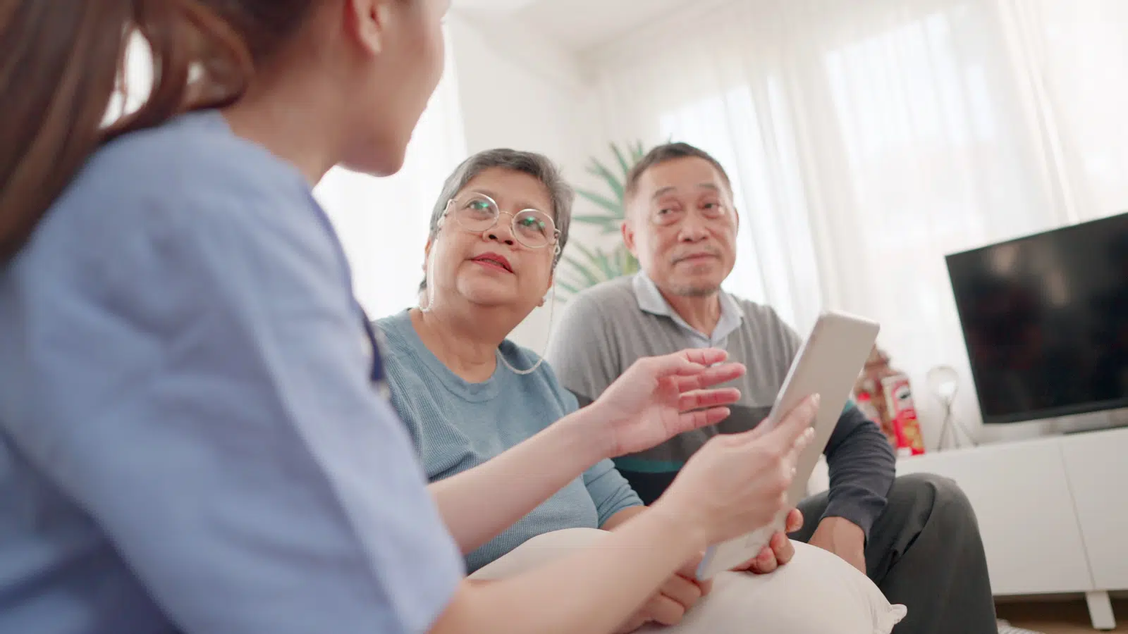 A Caregiver’s Guide to Long-Term Care Planning Feature Image: Professionals Asian female doctors consultations for the elderly couple, presentations check-up health, or share test results using a digital tablet, and discuss their health concerns of them