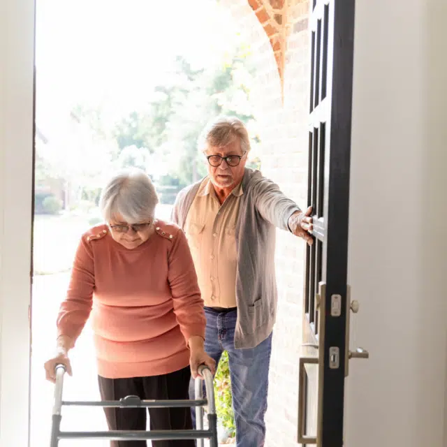 Home Safety Tips for Older Adults Feature Image: Older Couple Entering Home, Assistance and Support