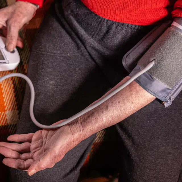 How to Manage High Blood Pressure Feature Image: Older woman measuring blood pressure at home.