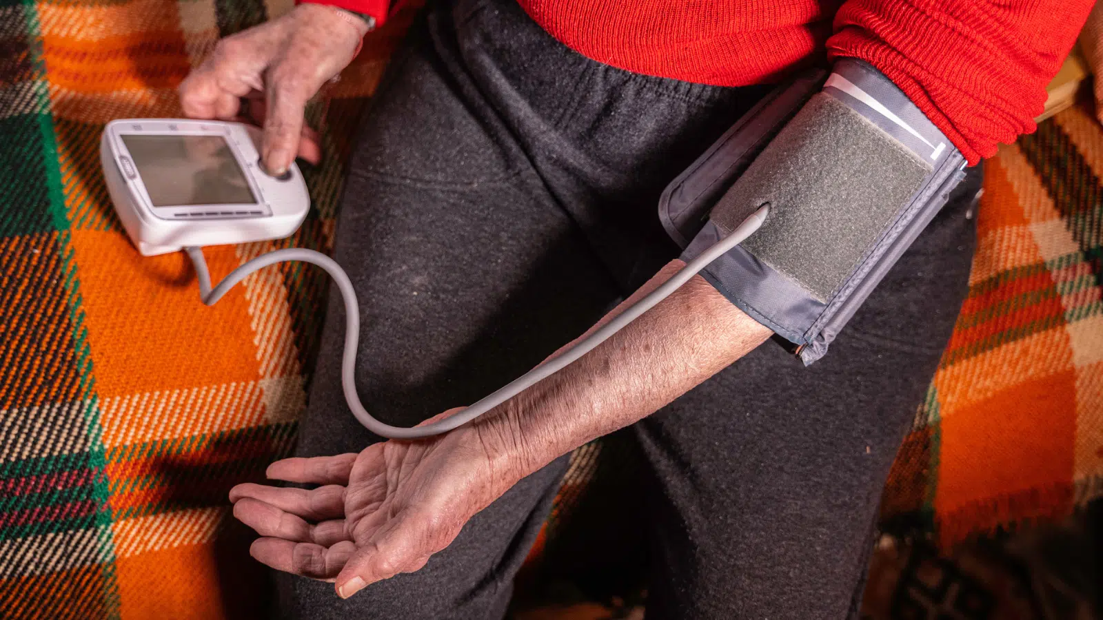 How to Manage High Blood Pressure Feature Image: Older woman measuring blood pressure at home.